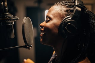 Singer singing into microphone in recording studio