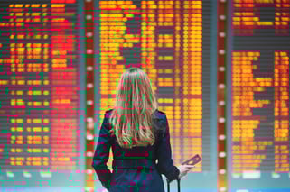 Traveler looking at departures board airport