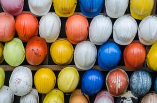 Wall of colourful hard hats at construction site
